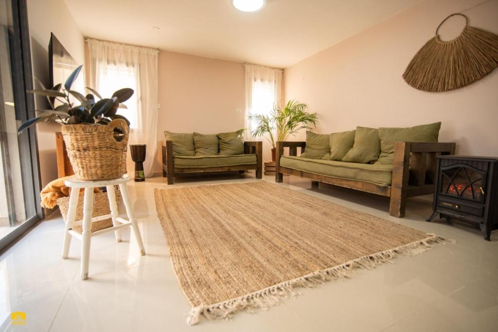 una sala de estar con 2 sofás y una alfombra en צימר עלמא en Yeruham