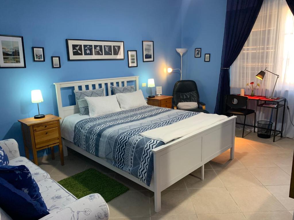 1 dormitorio con cama y pared azul en Stephen Center B&B, en Tirana