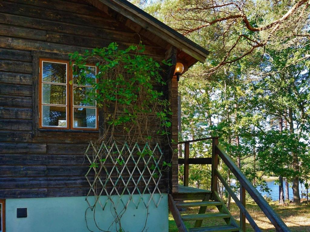 Cette maison en bois dispose d'un escalier et d'une fenêtre. dans l'établissement Holiday Home Eknöstigen, à Adriansnäs