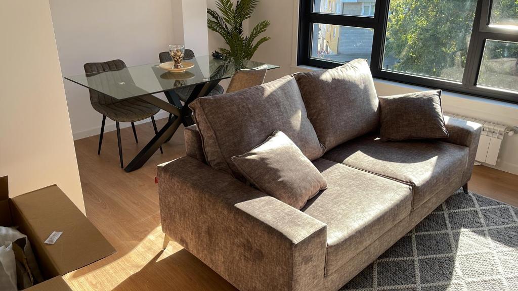 a living room with a couch and a glass table at Oktheway Areal in Oleiros