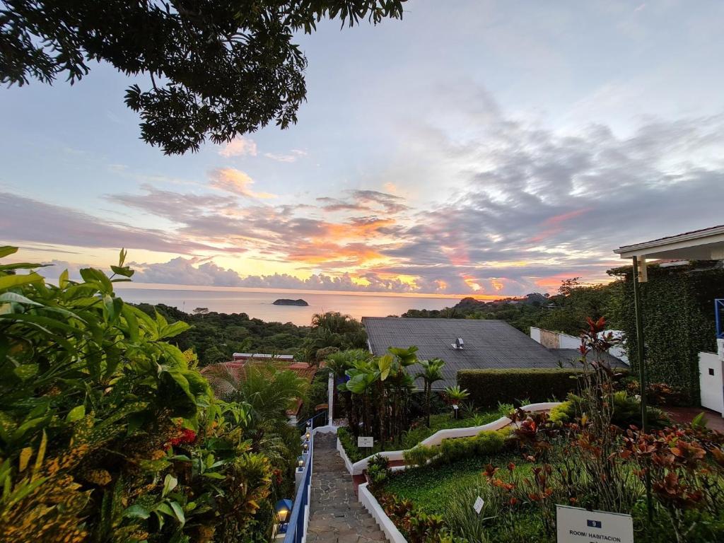 a view of the ocean at sunset from a house at Villa Roca Boutique Resort & Suites - ADULT ONLY in Manuel Antonio