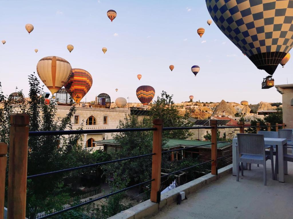 um grupo de balões de ar quente sobrevoando uma cidade em Falcon Cave Suites em Goreme