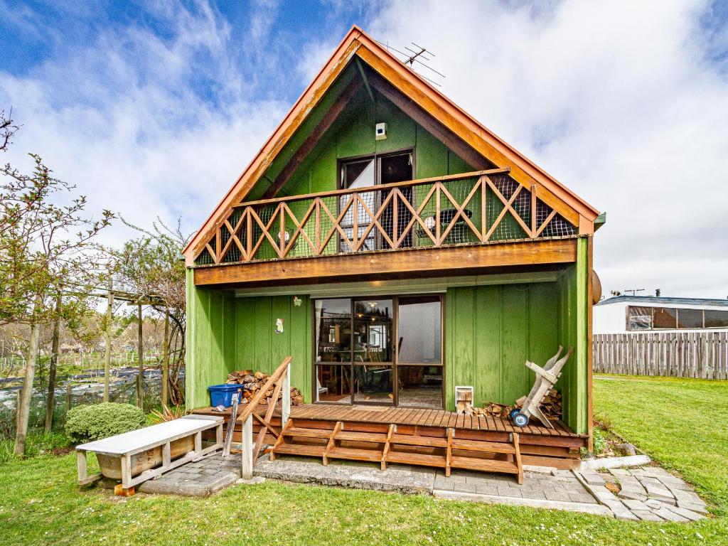 a green tiny house with a porch and a deck at Green Gables - Raetihi Holiday Home in Raetihi