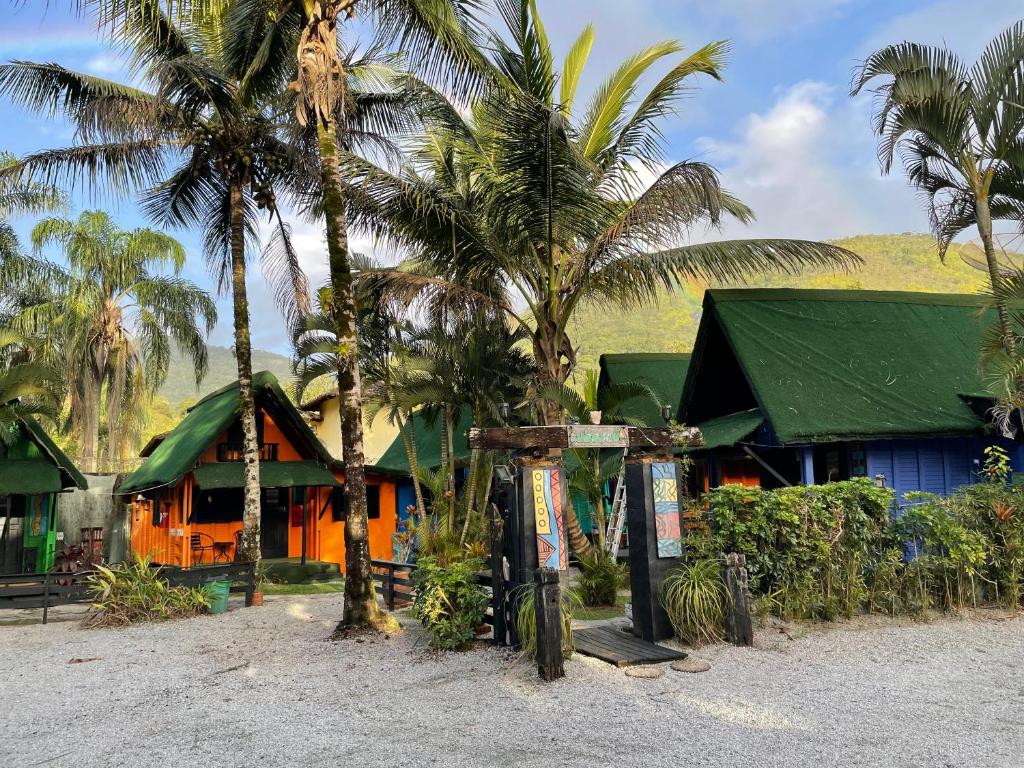 une maison avec des palmiers devant elle dans l'établissement Alemao Cabanas, à Camburi