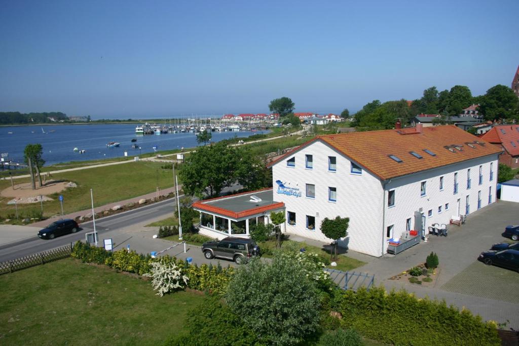 a white building with a red roof next to a street at Haffidyll garni in Rerik