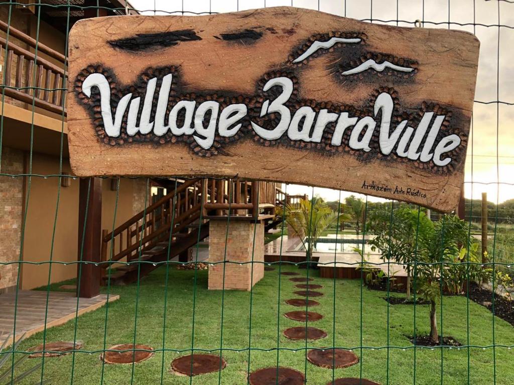 a sign on a fence in front of a building at Apartamento Barra Grande Península de Marau Bahia in Marau