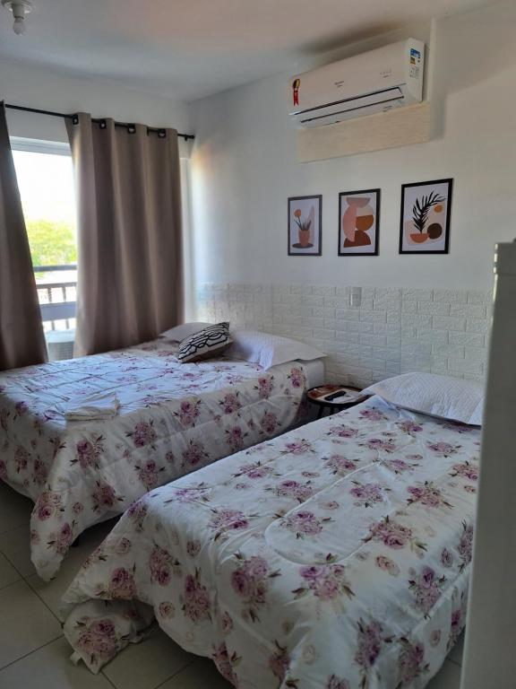 a bedroom with two beds and a window at Flat 308 in Teresina