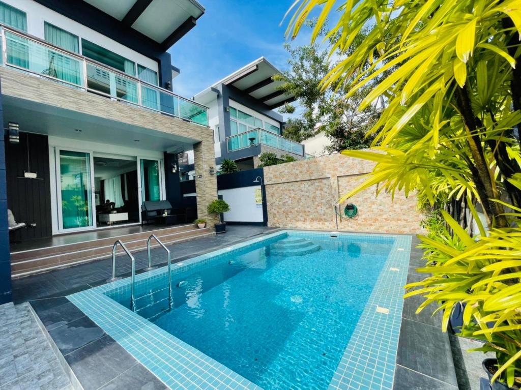 芭達雅中心的住宿－KW pool villa pattaya，一座房子后院的游泳池
