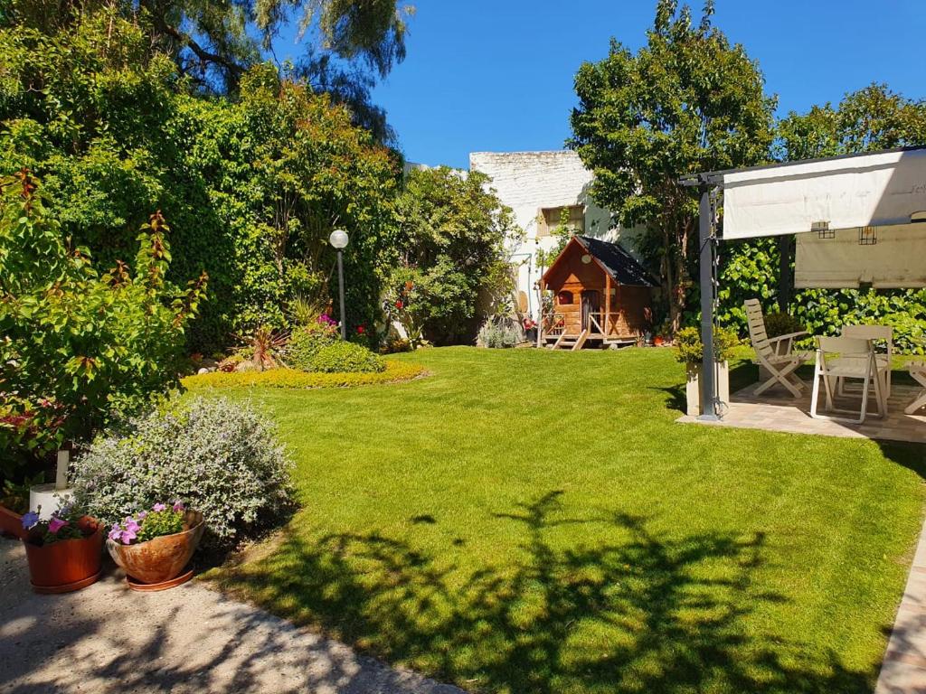 un patio trasero con césped con plantas y una casa en Casa Golfo Nuevo en Puerto Madryn