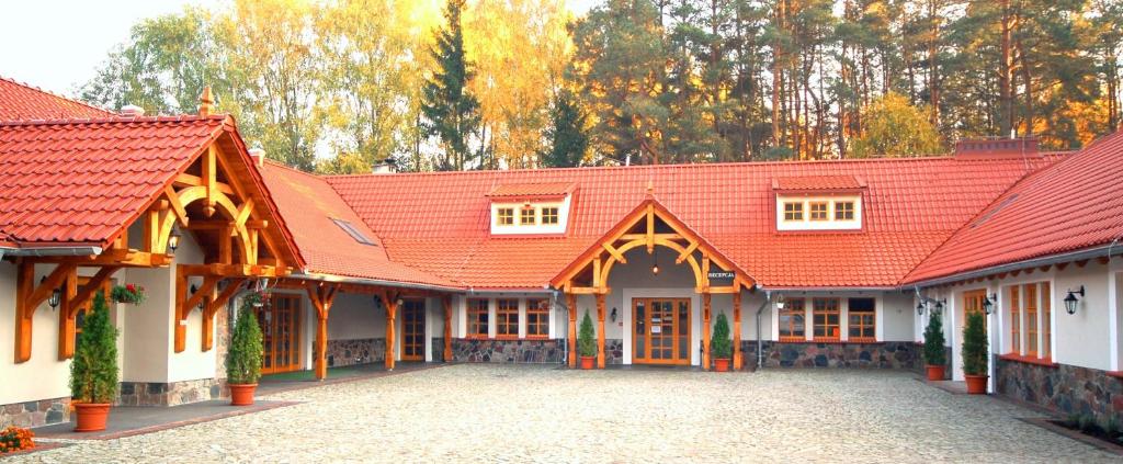 un bâtiment avec un toit orange et une cour dans l'établissement Ośrodek Wypoczynkowy Hartek, à Ostaszewo