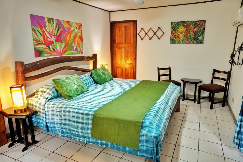 a bedroom with a bed, desk, chair, and lamp at La Quinta Sarapiqui Lodge in Sarapiquí