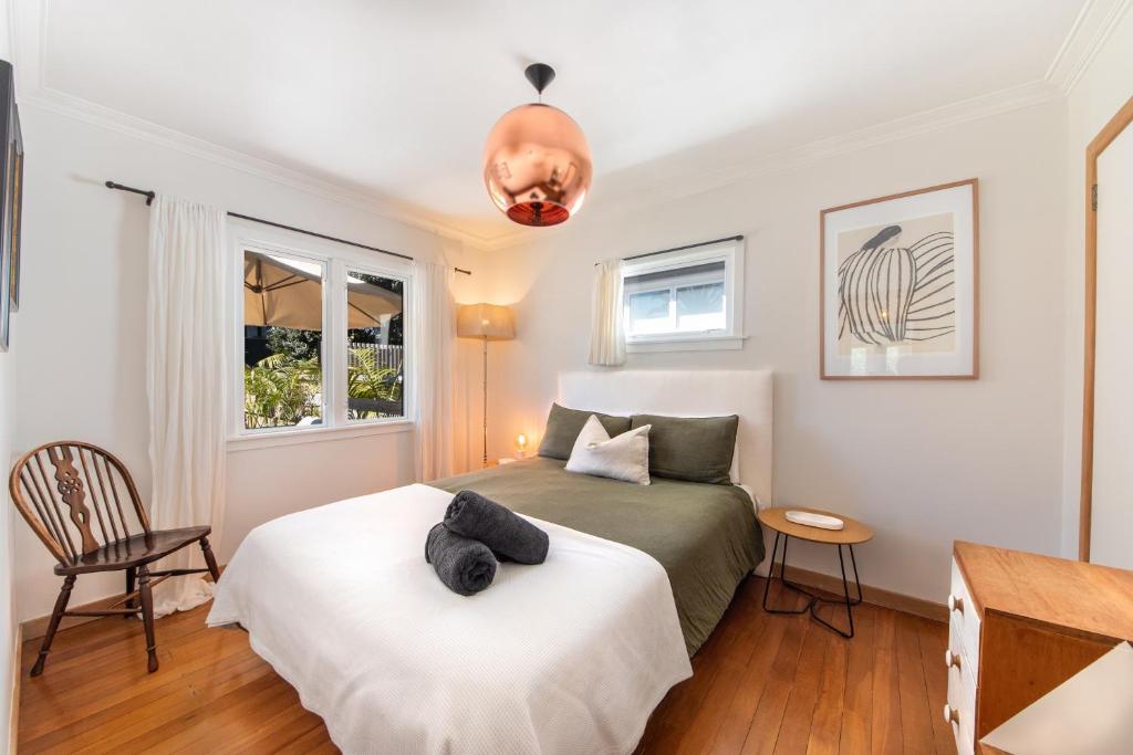 a bedroom with a bed and a desk at The Coastal Casa ~ Close to the beach and town in Mount Maunganui