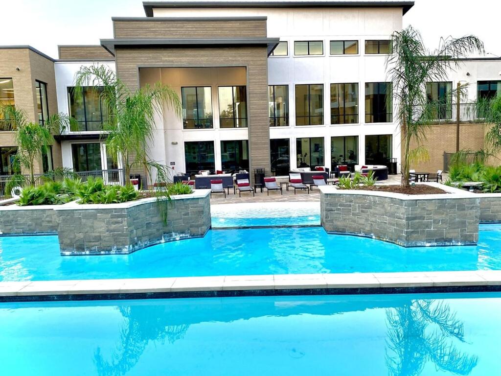 a swimming pool in front of a building at Beautiful 3 Bedroom Apartment in Bryan