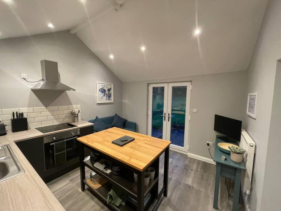uma cozinha com uma mesa de madeira num quarto em Beautiful self-catering cottages, Ribble Valley em West Bradford