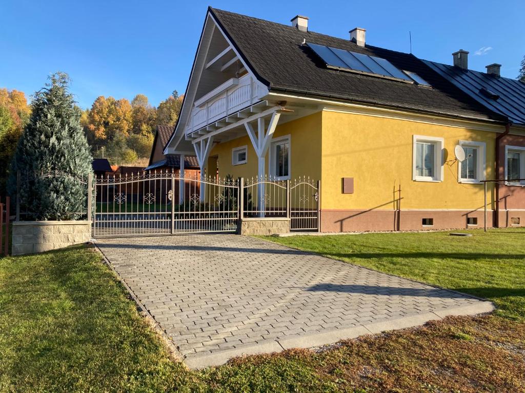 a yellow house with a gate in front of it at U poľovníka in Levoča