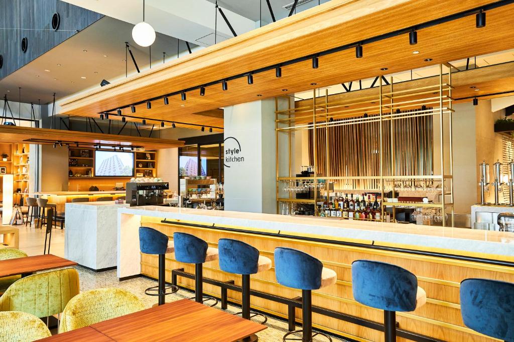 a restaurant with blue chairs and a bar at Nikko Style Nagoya in Nagoya