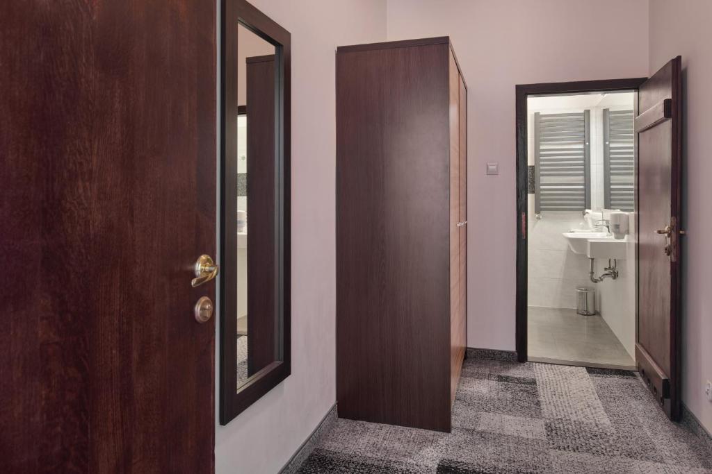 a bathroom with a door and a mirror and a sink at Morando in Zamość