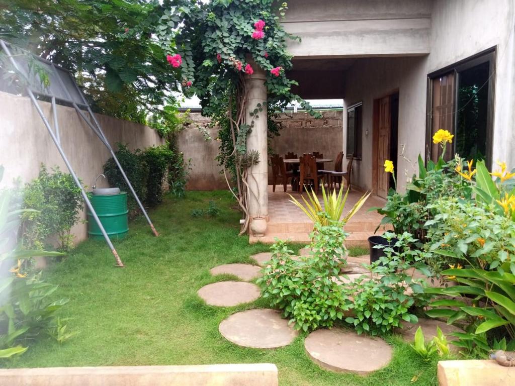 a garden with stepping stones in the grass at Villa ETE-D in Bohicon