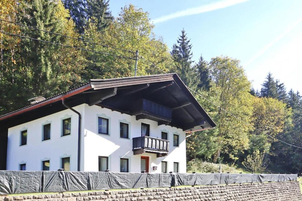 een wit huis met een balkon op een hek bij holiday home Grünbacher, Kössen in Kössen
