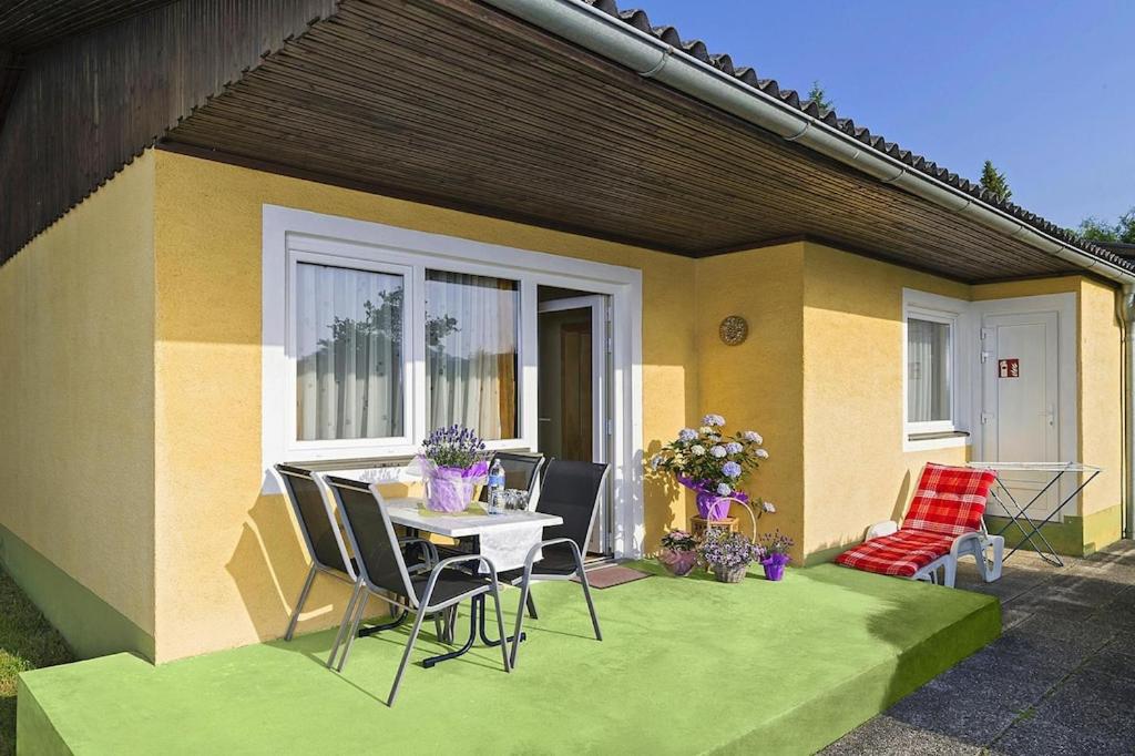 a patio with a table and chairs in front of a house at Bungalow in St Kanzian am Klopeler See with a terrace in Unternarrach