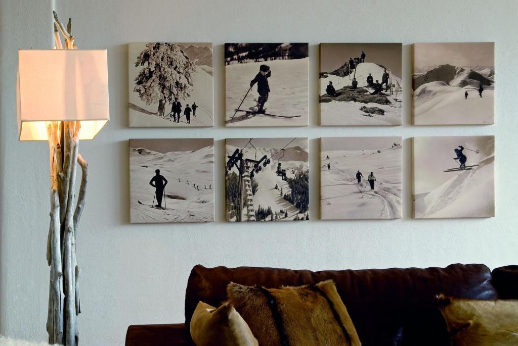 a bunch of pictures on a wall in a living room at Kitzhof Mountain Design Resort in Kitzbühel