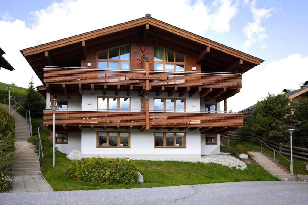 a large house with a wooden roof at Holiday flat B rlerhof XXL K nigsleiten in Königsleiten