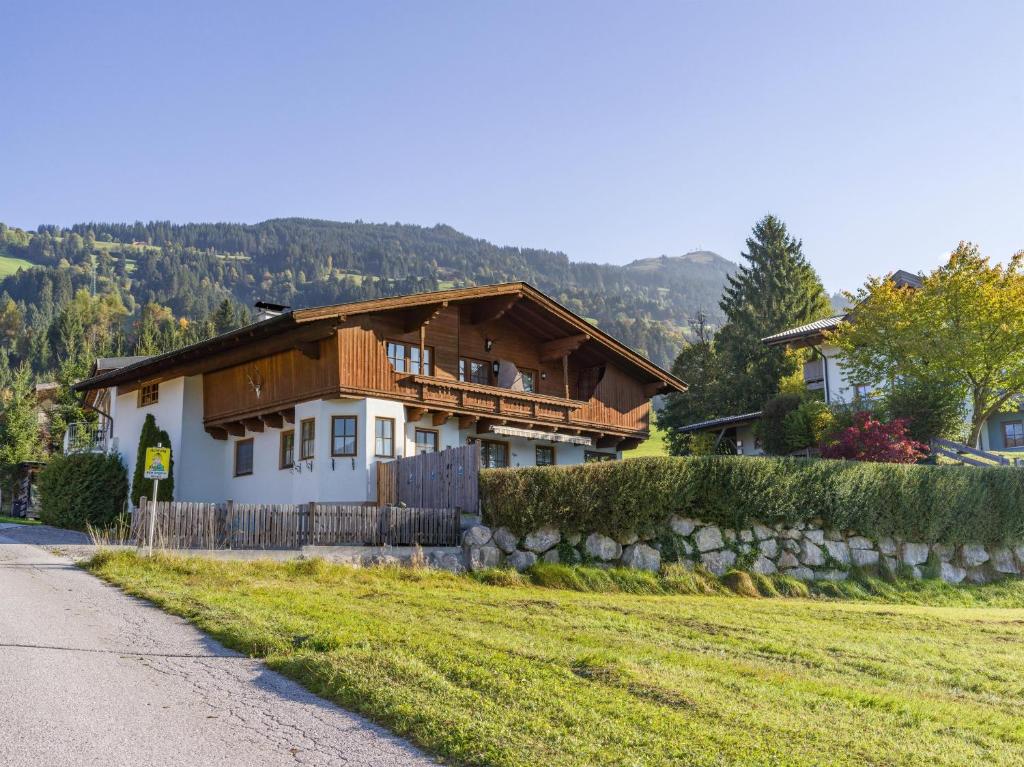 a house with a wooden roof on a field at Ferienwohnung Pacher in Hopfgarten im Brixental