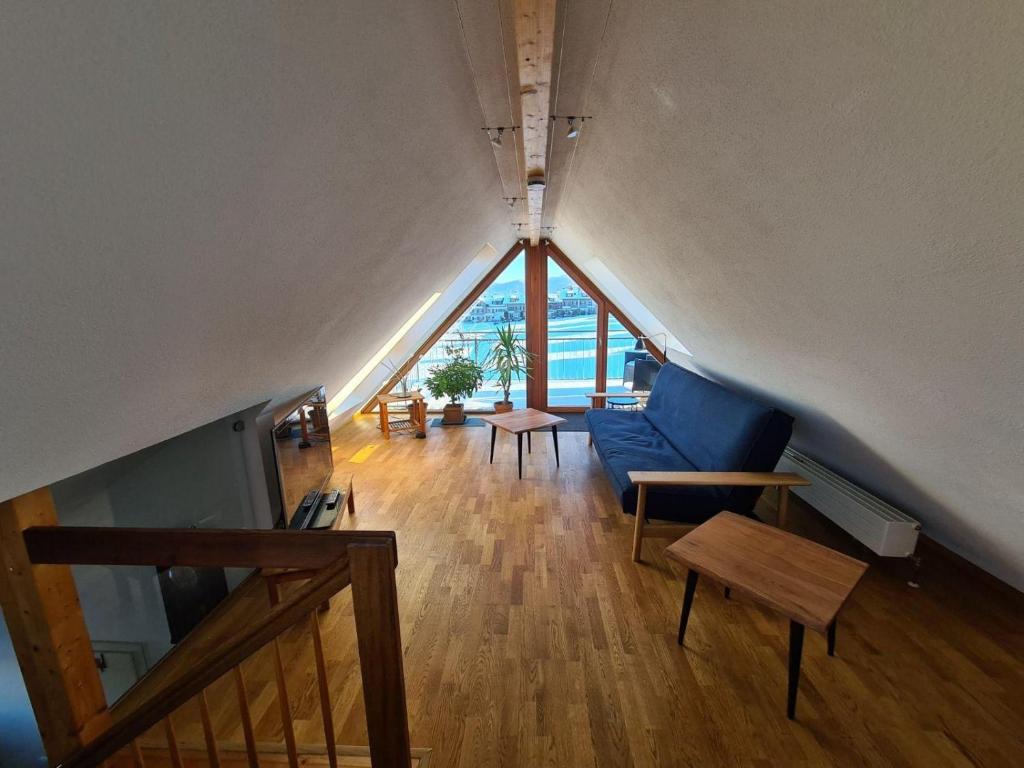 ein Wohnzimmer mit einer blauen Couch und einem großen Fenster in der Unterkunft Ferienwohnung Rotmoosblick direkt am Rande unberührter Natur in Isny im Allgäu