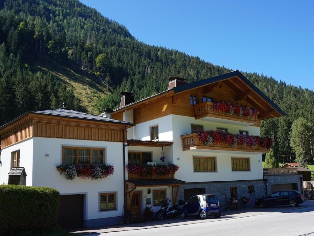 a large building with flowers on the balconies of it at Apartment house Sylvia, Flachau in Flachau