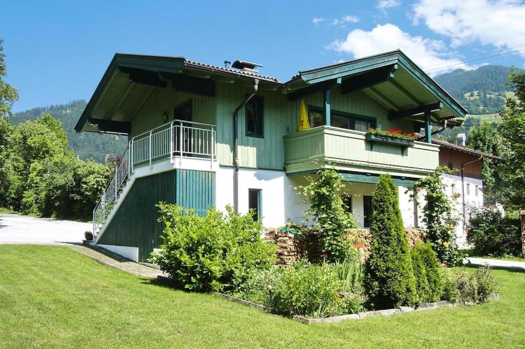 een groot groen en wit huis met een balkon bij holiday home, Itter in Itter