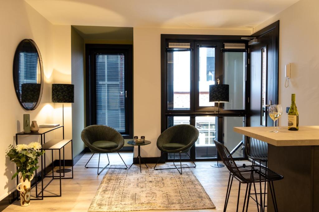 een woonkamer met stoelen en ramen bij City Stay&Go Enschede in Enschede