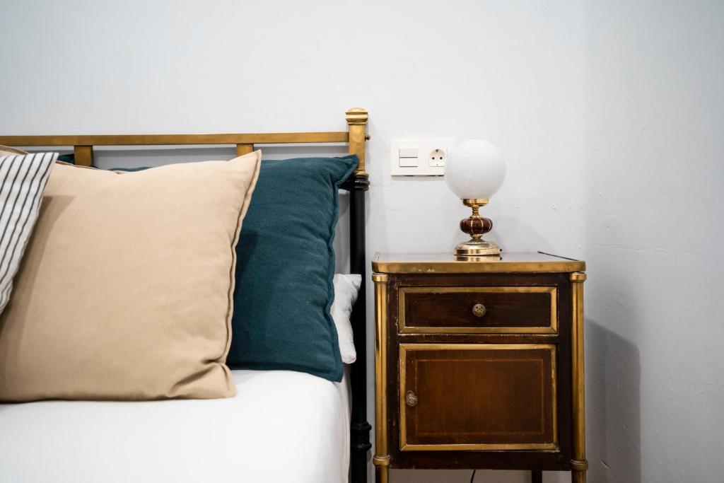 ein Bett mit einem Beistelltisch mit einer Lampe darauf in der Unterkunft HiHome Hostel in Oviedo