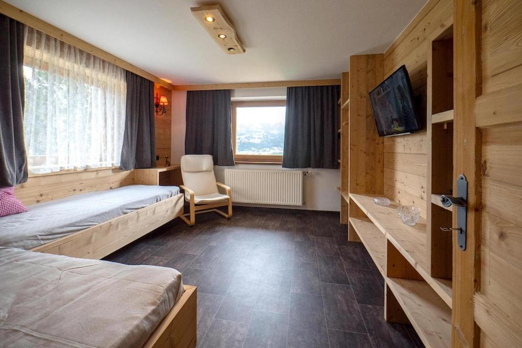 Zimmer mit 2 Betten, einem TV und einem Stuhl in der Unterkunft holiday home, Fügen in Fügen