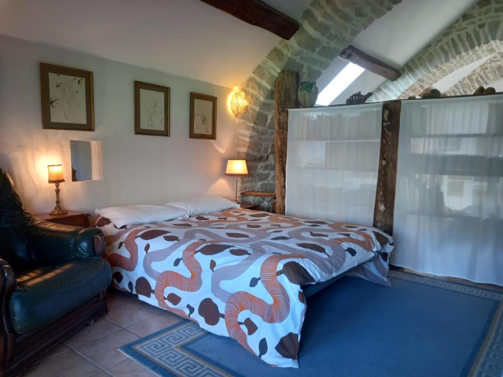 1 dormitorio con 1 cama y 1 sofá en Gîte La Grange, en Saint-Laurent-dʼOlt