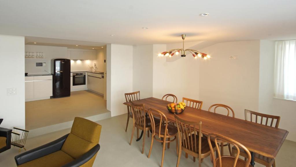 a kitchen and dining room with a wooden table and chairs at Alte Metzg - Hostel in Appenzell