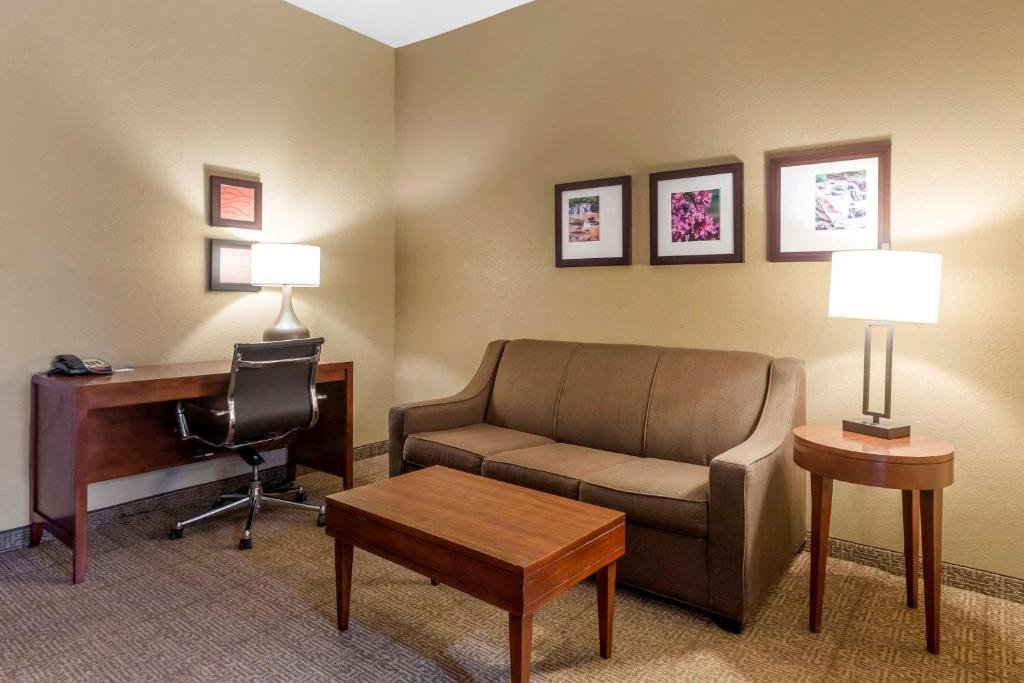 a living room with a couch and a desk and a computer at Comfort Inn & Suites Peachtree Corners in Norcross