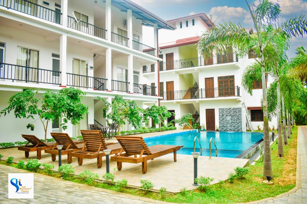 a hotel with a swimming pool in front of a building at Hotel Summer Haven in Polonnaruwa