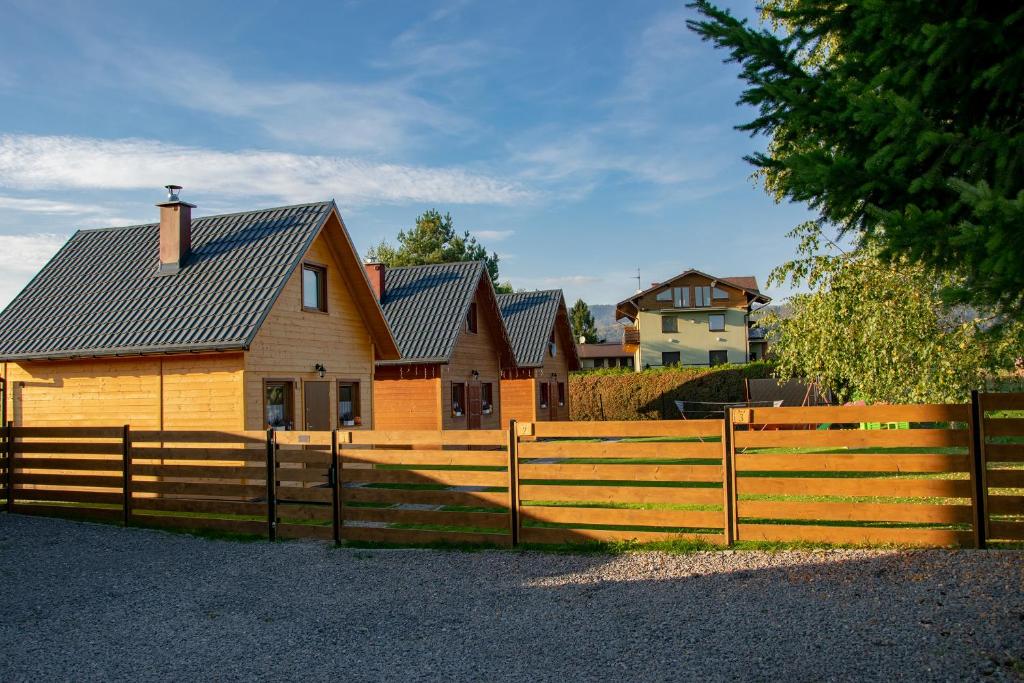 a wooden fence in front of a house at Domki nad jeziorem in Zarzecze