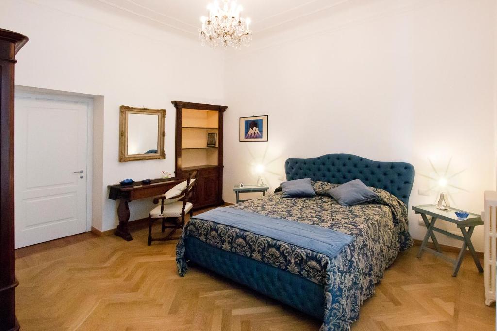 a bedroom with a blue bed and a desk at IMHOME - Porta Romana in Milan