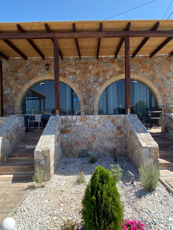 a stone building with a wooden pergola at Blue Sky in Frangokastello