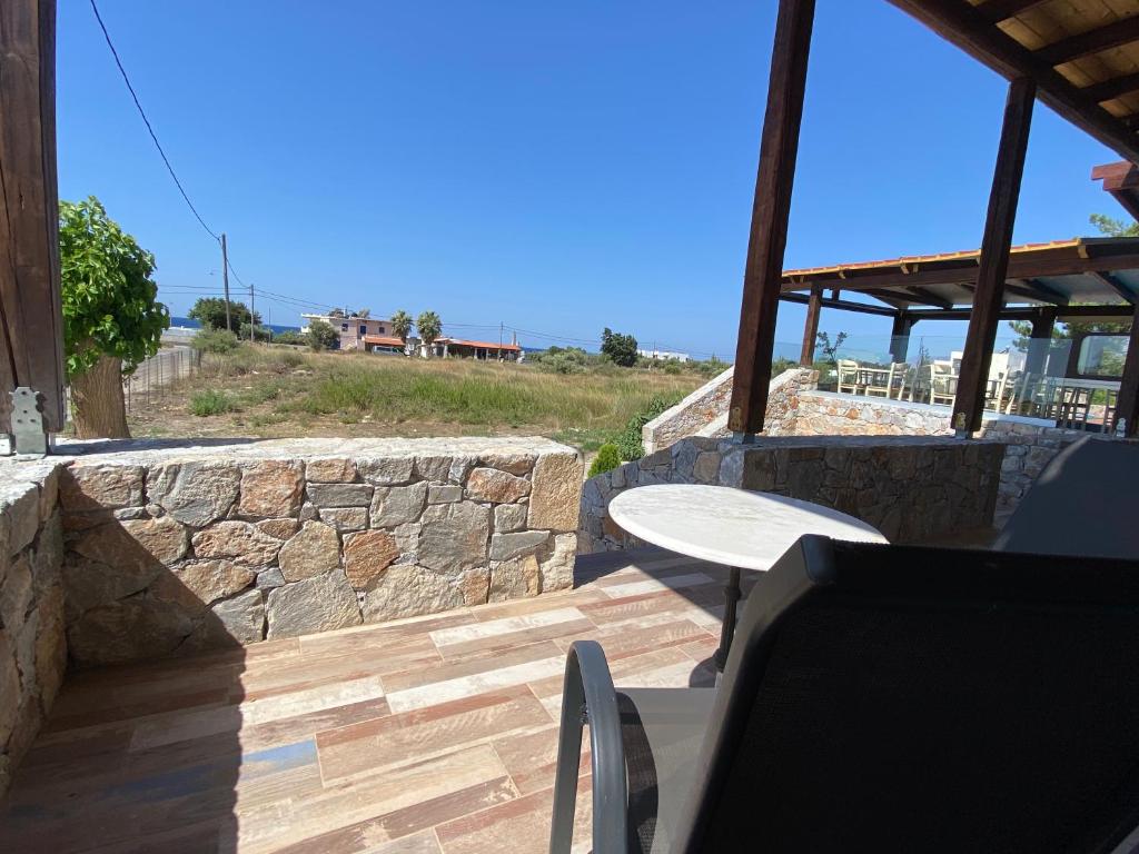 a patio with a table and a stone wall at Blue Sky in Frangokastello