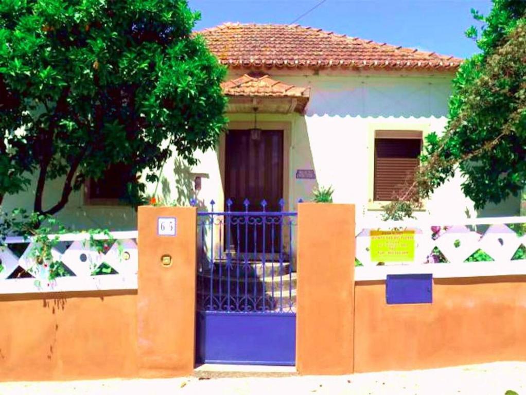 ein Haus mit einem blauen Tor und einem Zaun in der Unterkunft Lovely 4-Bed Cottage near Pedrogao Grande in Pedrógão Grande