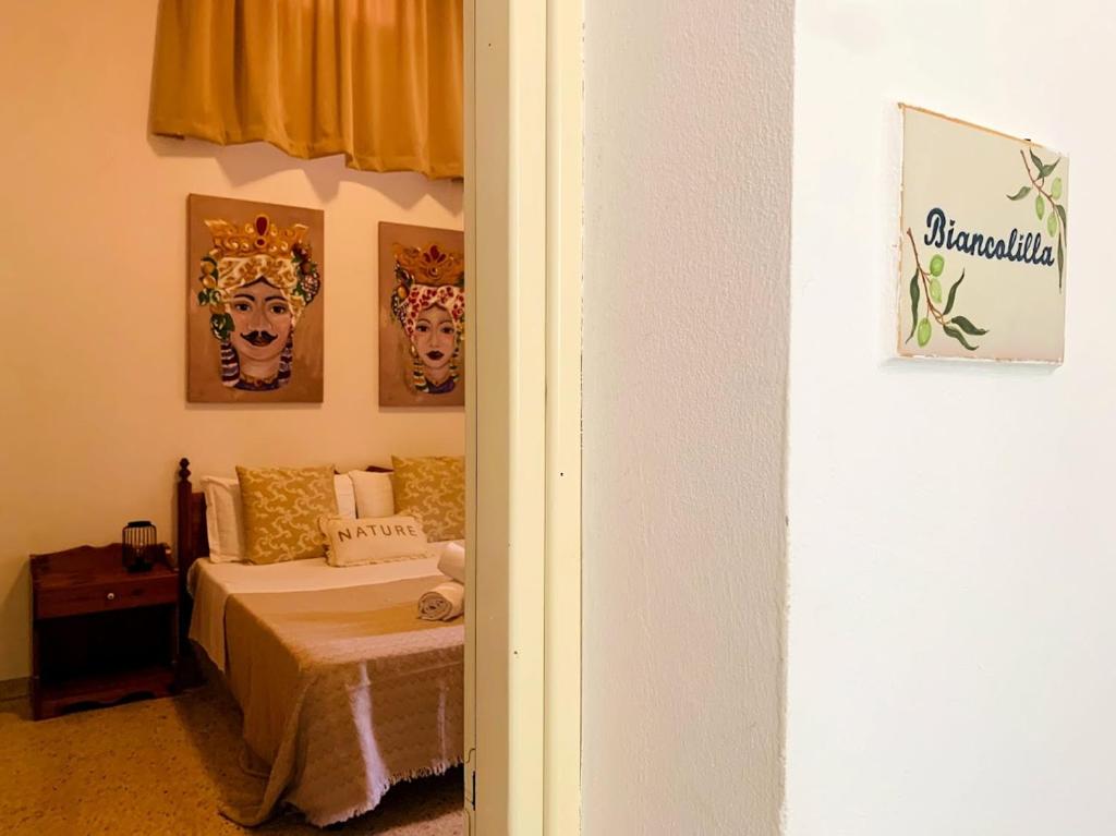 a bedroom with a bed with two masks on the wall at Agriturismo Carbona in Castelvetrano Selinunte