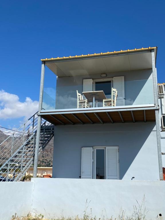 a house with two chairs and a table on the balcony at Blue Sky in Frangokastello