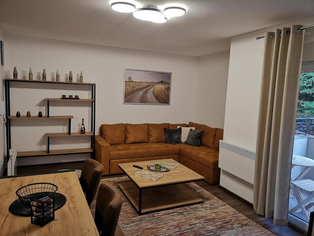 ein Wohnzimmer mit einem Sofa und einem Tisch in der Unterkunft Zlatar Holidays Apartmani in Nova Varoš