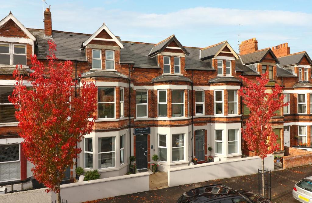 a row of houses with red trees in front of them at Titanic Guest Boutique, 4-Star Accommodation in Belfast