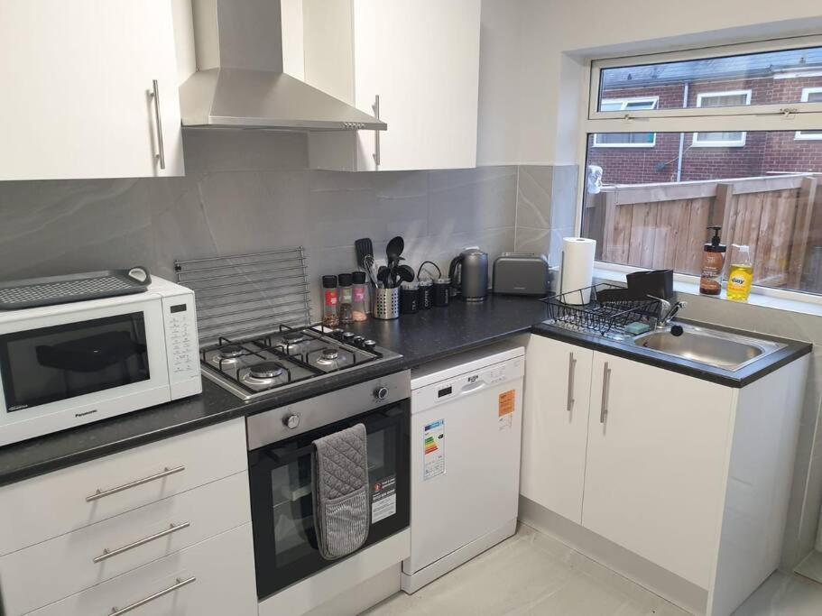 a kitchen with a microwave and a stove top oven at Chester Le Street Amythyst 3 Bedroom House in Chester-le-Street