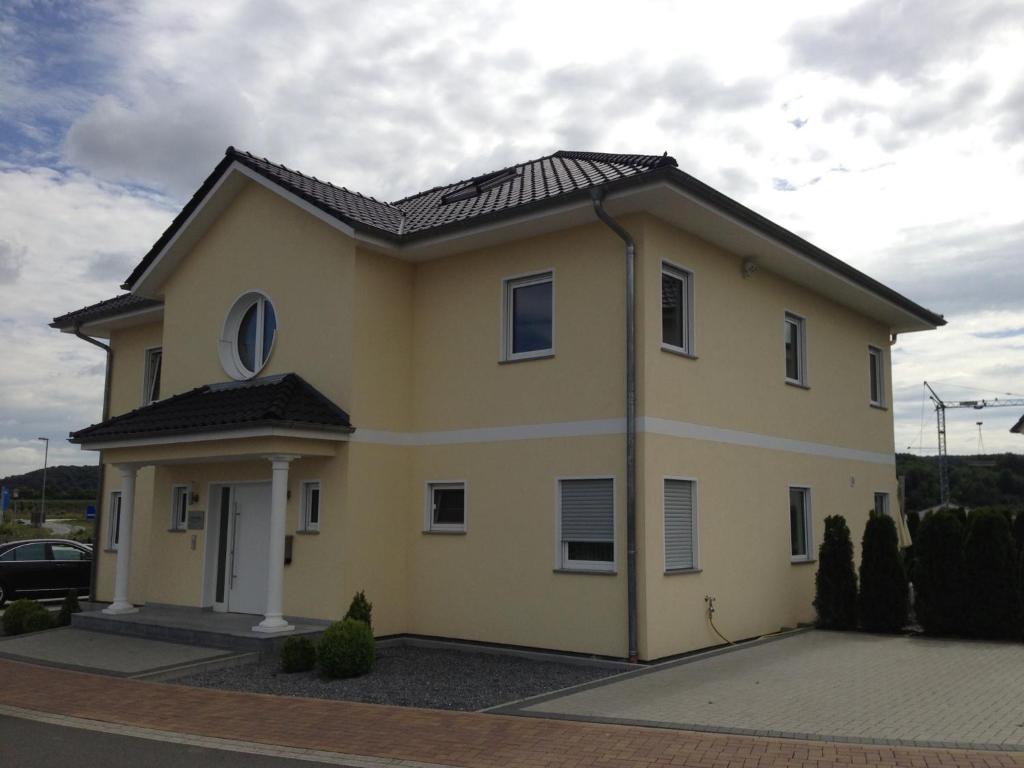 a large yellow house with a black roof at Gästehaus Werns in Hammersbach