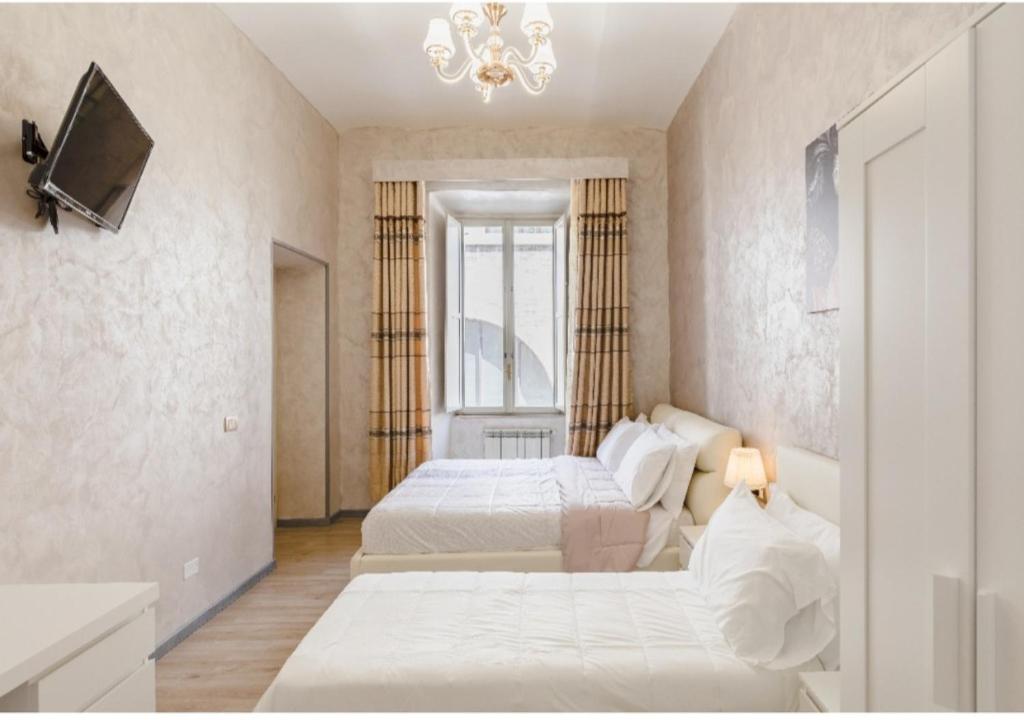una camera da letto con due letti e un lampadario di Rome Place a Roma