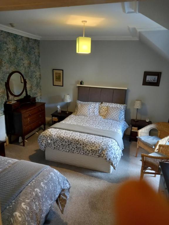 a bedroom with a bed and a dresser and a mirror at The Tushielaw Inn in Selkirk